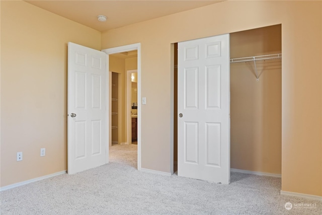 unfurnished bedroom with light colored carpet and a closet