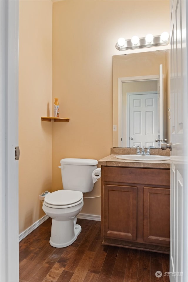 bathroom featuring vanity, hardwood / wood-style floors, and toilet