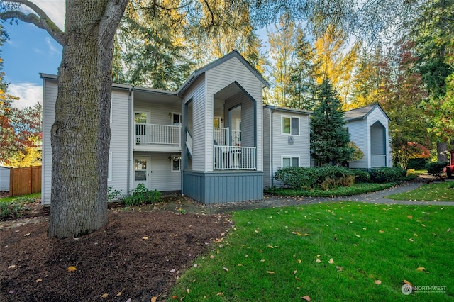 view of front facade featuring a front lawn and a balcony