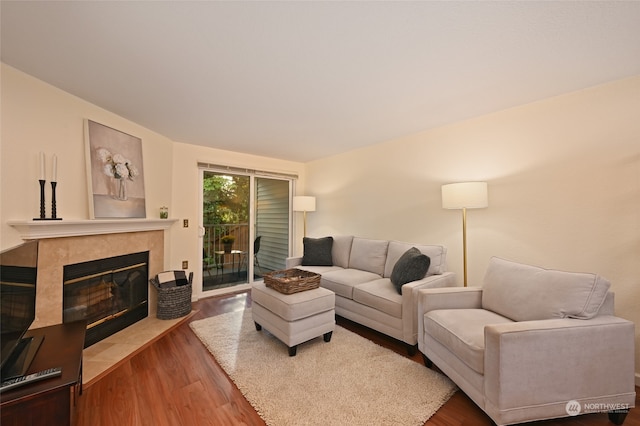 living room featuring hardwood / wood-style flooring and a tile fireplace