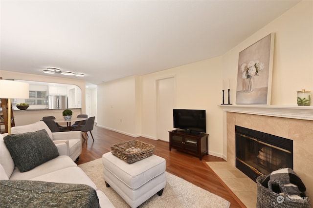 living room featuring a tile fireplace and light hardwood / wood-style floors