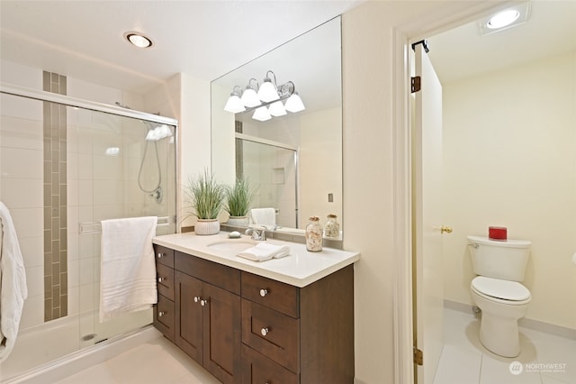 bathroom featuring toilet, vanity, tile patterned floors, and walk in shower