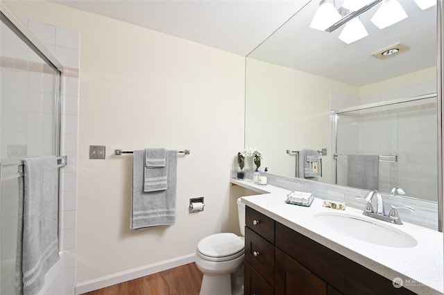 bathroom with hardwood / wood-style flooring, a shower with shower door, toilet, and a skylight