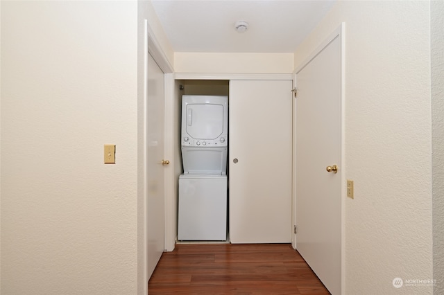 hallway featuring dark wood-type flooring and stacked washer / drying machine