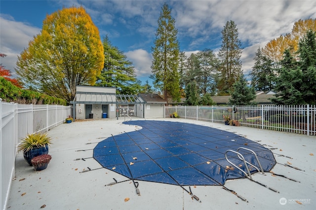 view of swimming pool with an outbuilding and a patio