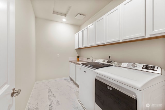 laundry area with cabinets, separate washer and dryer, and sink