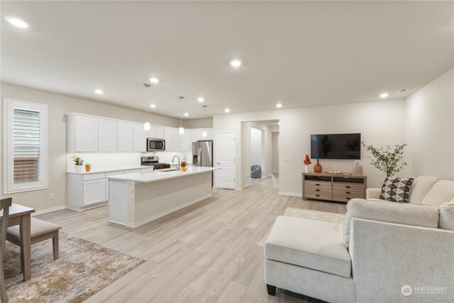 living room with sink and light hardwood / wood-style floors