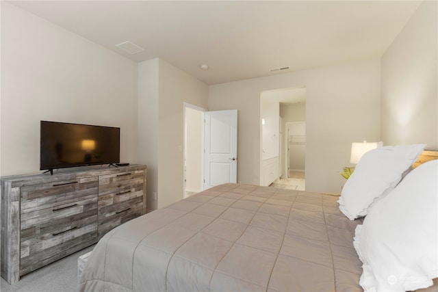 carpeted bedroom featuring ensuite bath