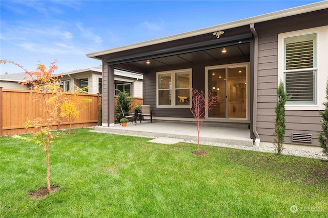 rear view of house featuring a yard and a patio area