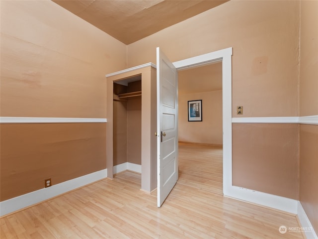 unfurnished bedroom featuring light hardwood / wood-style floors and a closet