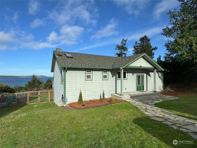 view of front facade with a patio, a water view, and a front lawn