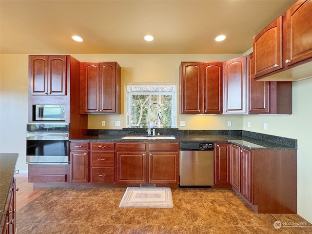 kitchen featuring dark stone countertops, hardwood / wood-style floors, appliances with stainless steel finishes, and sink