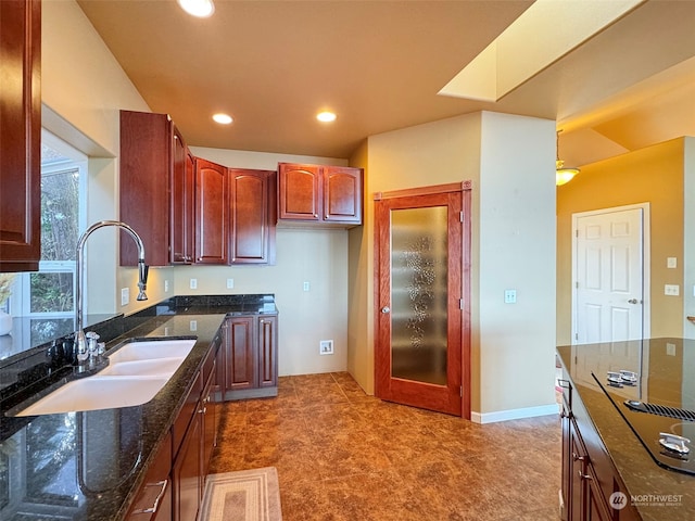 kitchen featuring dark stone counters and sink