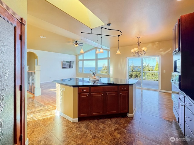 kitchen with appliances with stainless steel finishes, a wealth of natural light, pendant lighting, and a center island