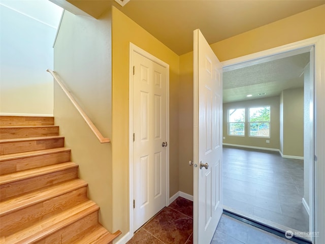 staircase with tile patterned floors and a textured ceiling