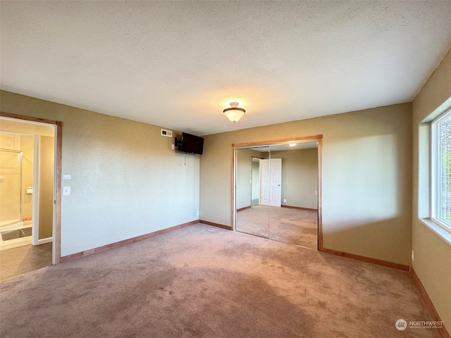 spare room with a textured ceiling and carpet floors