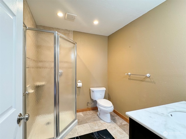 bathroom featuring tile patterned flooring, vanity, toilet, and a shower with door