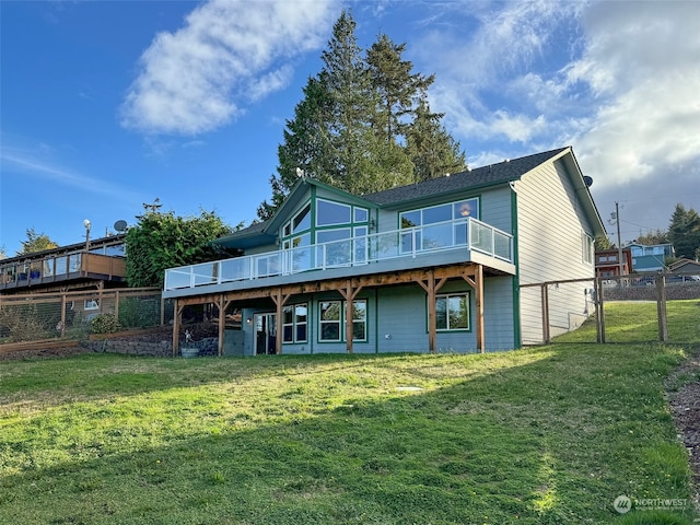 rear view of property featuring a yard and a deck