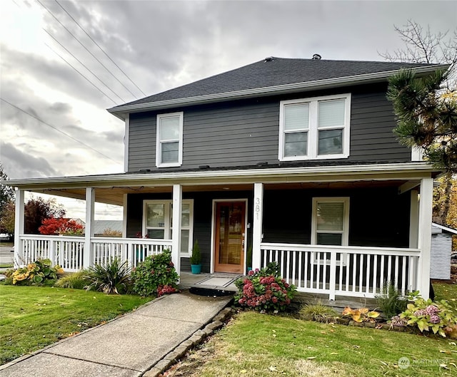 farmhouse-style home with a front lawn and covered porch