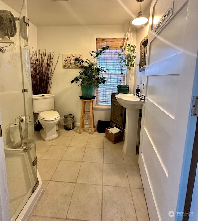 bathroom with walk in shower, tile patterned floors, toilet, and sink