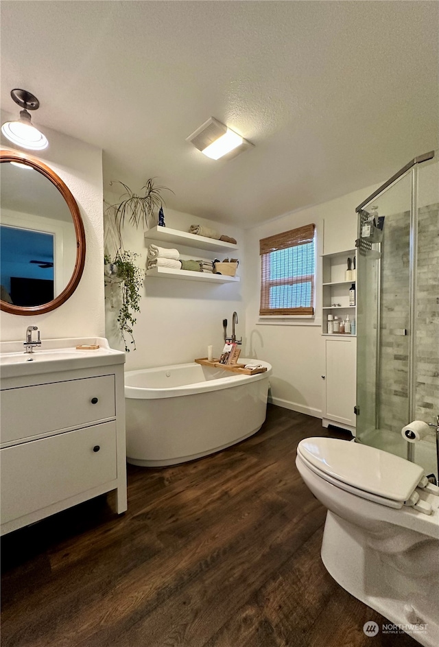 full bathroom with toilet, hardwood / wood-style floors, a textured ceiling, vanity, and independent shower and bath