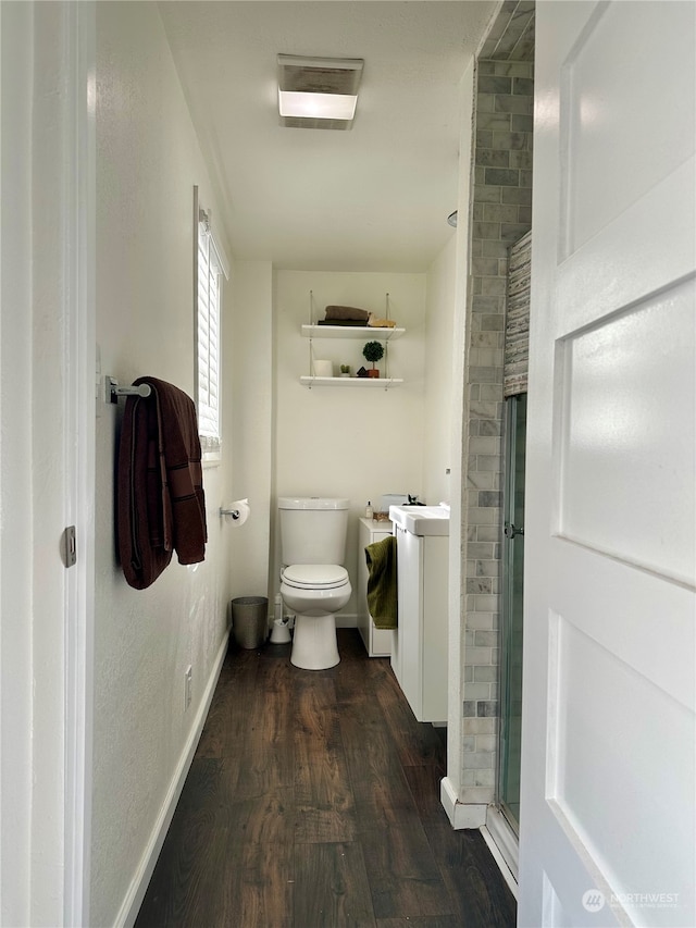 bathroom with hardwood / wood-style floors, vanity, toilet, and an enclosed shower