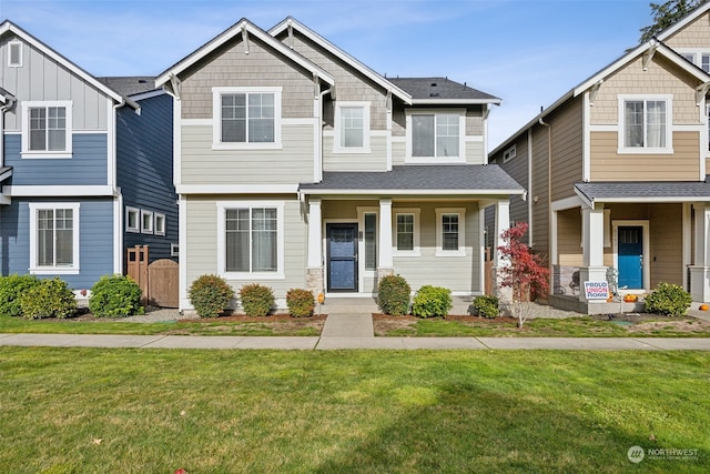 craftsman inspired home featuring a porch and a front yard