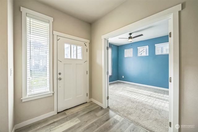 entrance foyer featuring light hardwood / wood-style flooring, ceiling fan, and plenty of natural light