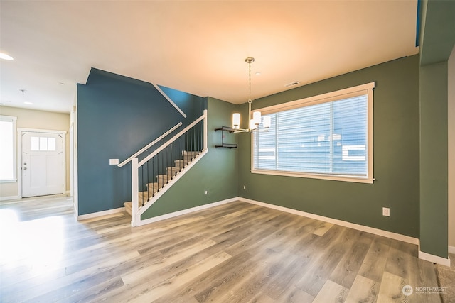 unfurnished dining area with hardwood / wood-style flooring and a notable chandelier