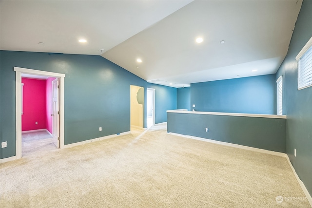 spare room with light colored carpet and lofted ceiling