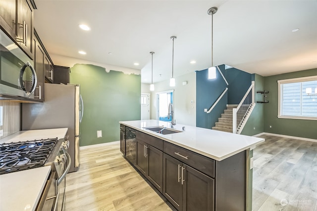 kitchen with light hardwood / wood-style floors, a wealth of natural light, sink, and a center island with sink