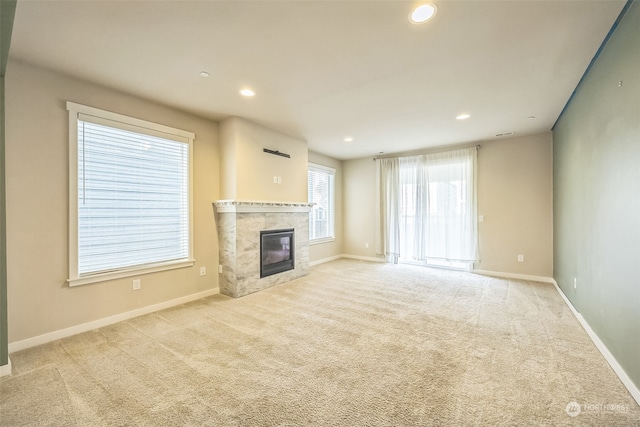 unfurnished living room with light carpet and a tile fireplace