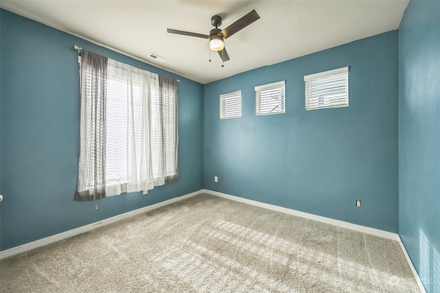 carpeted spare room featuring ceiling fan