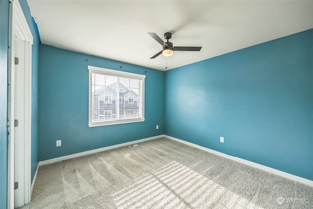 carpeted spare room featuring ceiling fan