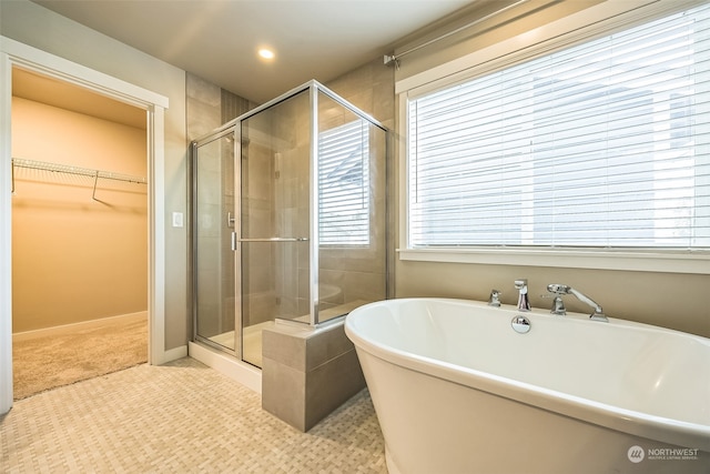 bathroom with a wealth of natural light and shower with separate bathtub