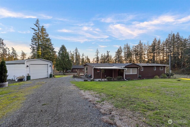 view of front of house with an outbuilding, a front yard, and a garage