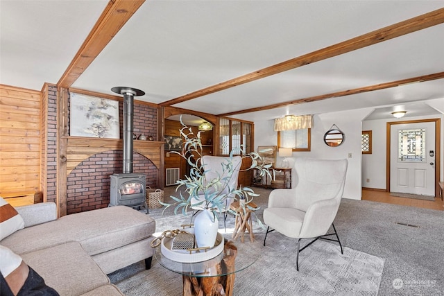288 Torrence Ln, Oak Harbor, WA 98277 - living room with a wood stove, wooden walls, beam ceiling, and arched walkways