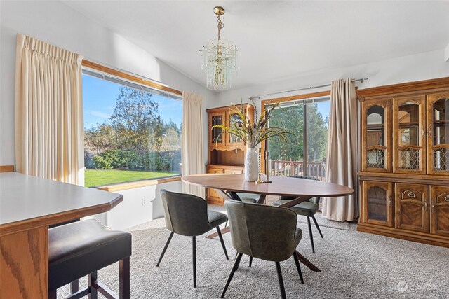 carpeted dining area with vaulted ceiling and an inviting chandelier