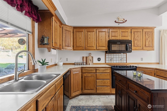 kitchen featuring sink, black appliances, and lofted ceiling