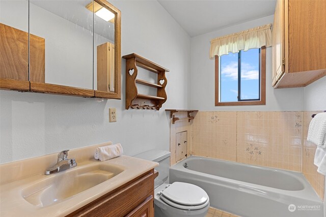 bathroom featuring vanity, toilet, and a bath