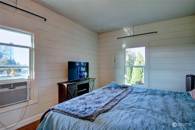 bedroom featuring wood walls, cooling unit, and dark hardwood / wood-style floors