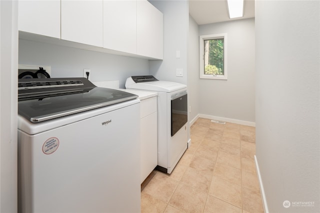 laundry room with cabinets, separate washer and dryer, and light tile patterned floors