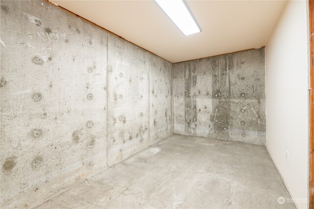 unfurnished room with concrete flooring