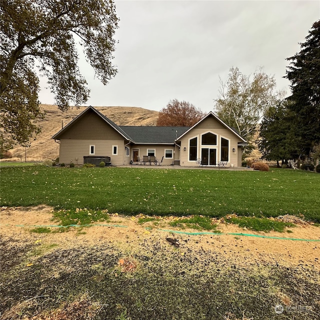 rear view of house with a yard and a patio