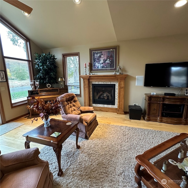 living room with light wood-type flooring, high vaulted ceiling, and a healthy amount of sunlight