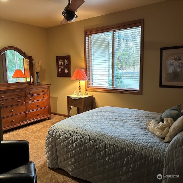 carpeted bedroom featuring multiple windows and ceiling fan