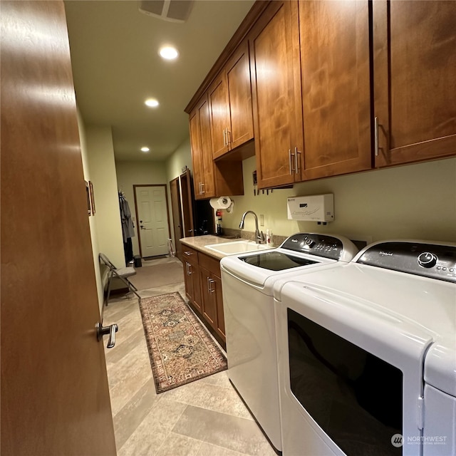 laundry room featuring cabinets, independent washer and dryer, and sink