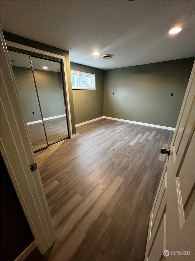 unfurnished bedroom featuring hardwood / wood-style floors and a closet