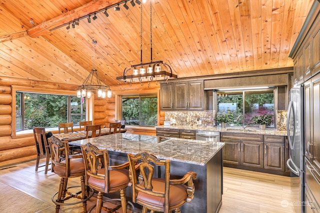 kitchen featuring rustic walls, light hardwood / wood-style floors, a center island, and wood ceiling