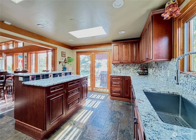 kitchen featuring a kitchen island, sink, a wealth of natural light, and a skylight